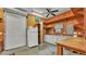 Spacious garage interior with workbench, shelves, fridge, and roll-up door for easy access at 323 E Belvedere St, Lakeland, FL 33803