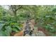 Peaceful backyard featuring a stream with rocks, surrounded by lush greenery and mature trees at 323 E Belvedere St, Lakeland, FL 33803