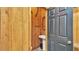 Rustic powder room with wood paneling, pedestal sink, and a dark-colored door with a logo on top at 323 E Belvedere St, Lakeland, FL 33803