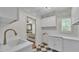 A utility room with black and white tile flooring, white cabinets, and a view into the bathroom at 323 E Belvedere St, Lakeland, FL 33803