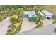 An aerial view showcasing the house, landscaping, tiki hut and RV parking at 3243 Red Tail Hawk Dr, Polk City, FL 33868