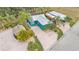 Aerial view of turquoise home with metal roof, tiki hut and RV parking at 3243 Red Tail Hawk Dr, Polk City, FL 33868