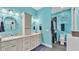 Bright bathroom featuring a double sink vanity, granite countertop and grey cabinets, adjacent to a shower with glass doors at 3243 Red Tail Hawk Dr, Polk City, FL 33868