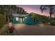 Beautiful blue home with a metal roof and brick driveway is surrounded by trees and landscaping at 3243 Red Tail Hawk Dr, Polk City, FL 33868