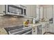 A close-up shot showcasing kitchen's updated stainless appliances, granite countertops, and stylish backsplash at 3243 Red Tail Hawk Dr, Polk City, FL 33868