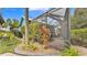Landscaped yard leads to a screened-in patio with seating, perfect for outdoor enjoyment at 3243 Red Tail Hawk Dr, Polk City, FL 33868