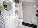 Modern bathroom featuring a sleek vanity, toilet, and a shower with bench seat with elegant marble-like tile at 355 E Columbia St, Lake Alfred, FL 33850