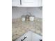 Close-up featuring granite countertop with elegant marble backsplash, complemented by stylish storage containers at 355 E Columbia St, Lake Alfred, FL 33850