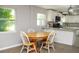 Bright dining area features an oak table, white chairs, and large windows overlooking the well landscaped property at 355 E Columbia St, Lake Alfred, FL 33850