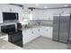 Well-lit kitchen boasting white cabinetry, stainless steel appliances, and stone countertops at 355 E Columbia St, Lake Alfred, FL 33850
