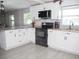 Modern kitchen features granite counters, white cabinets, and stainless steel appliances at 355 E Columbia St, Lake Alfred, FL 33850
