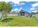 Lush backyard with privacy fence and mature tree offers a serene outdoor space at 420 Sir Phillips Dr, Davenport, FL 33837