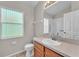 Bright bathroom with a dark wood vanity, large mirror, and window for natural light at 420 Sir Phillips Dr, Davenport, FL 33837
