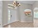 Bright foyer with tiled flooring, a chandelier, and a view into the kitchen at 420 Sir Phillips Dr, Davenport, FL 33837