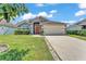 Charming single-story home with a well-manicured lawn, neutral paint, and an attached two-car garage at 420 Sir Phillips Dr, Davenport, FL 33837