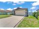 Well-maintained single-story home with a wide driveway leading to an attached two-car garage at 420 Sir Phillips Dr, Davenport, FL 33837
