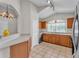 Well-lit kitchen with light wood cabinets, tile flooring, and a view into the foyer at 420 Sir Phillips Dr, Davenport, FL 33837