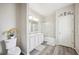 Bright bathroom with double sinks and shower-tub combo, adorned with stylish decor, and hardwood floors at 4303 Moon Shadow Loop, Mulberry, FL 33860