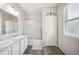 Well-lit bathroom featuring double sinks, hardwood floors and a shower-tub combo with glass doors at 4303 Moon Shadow Loop, Mulberry, FL 33860