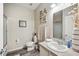Well-lit bathroom featuring a vanity sink, a framed mirror, and stylish decor with hardwood floors at 4303 Moon Shadow Loop, Mulberry, FL 33860