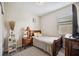Well-lit bedroom featuring a comfortable bed, stylish nightstand, and sleek gray wood-look floors at 4303 Moon Shadow Loop, Mulberry, FL 33860