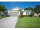 Charming single-story home featuring a well-manicured lawn and a two-car garage at 4303 Moon Shadow Loop, Mulberry, FL 33860