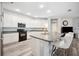 Modern kitchen with stainless steel appliances, white cabinetry, and a spacious center island at 4303 Moon Shadow Loop, Mulberry, FL 33860