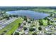 Aerial view of a community with a large lake, homes, and lush green landscaping on a sunny day at 440 Lake Daisy, Winter Haven, FL 33884