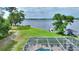 Lakeside home featuring a screened-in pool, expansive yard, and private dock at 440 Lake Daisy, Winter Haven, FL 33884