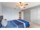 Cozy bedroom with carpet, ceiling fan, neutral paint, and a comfortable blue bed and white closet doors at 440 Lake Daisy, Winter Haven, FL 33884