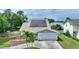 Stunning aerial view of the home with solar panels, lush landscaping, and waterfront views at 440 Lake Daisy, Winter Haven, FL 33884