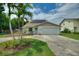 Charming single-story home featuring a two-car garage, solar panels, well-maintained landscaping, and palm trees at 440 Lake Daisy, Winter Haven, FL 33884