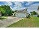 Inviting single-story home with a two-car garage, solar panels, light blue front door, and green lawn at 440 Lake Daisy, Winter Haven, FL 33884