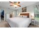 Bright main bedroom featuring a rustic bed frame, ceiling fan, and plentiful natural light at 440 Lake Daisy, Winter Haven, FL 33884