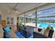 Relaxing covered patio with cozy seating, a ceiling fan, and a view of the pool and lake at 440 Lake Daisy, Winter Haven, FL 33884