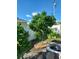 Backyard featuring a small avocado tree, white fence, and landscaping at 455 Eagle Dr, Kissimmee, FL 34759