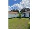Backyard features a white fence, lush lawn and tropical plants at 455 Eagle Dr, Kissimmee, FL 34759