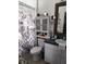 Bathroom with floral shower curtain, toilet, sink with vanity and framed mirror at 455 Eagle Dr, Kissimmee, FL 34759