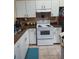 Traditional kitchen with white cabinets, laminate countertops, and a white range at 455 Eagle Dr, Kissimmee, FL 34759