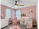 Bedroom with pink walls, white crib, and charming mermaid-themed décor at 511 Preserve Pointe Blvd, Davenport, FL 33837