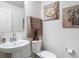 Well-lit powder room with elegant decor, a pedestal sink and tasteful artwork at 511 Preserve Pointe Blvd, Davenport, FL 33837