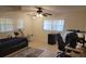 Bedroom includes a ceiling fan, two windows, tile flooring, and modern decor at 5121 Shady Oak S Dr, Lakeland, FL 33810