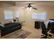 Bedroom includes a ceiling fan, two windows, tile flooring, and modern decor at 5121 Shady Oak S Dr, Lakeland, FL 33810