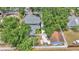 Aerial view of backyard featuring gray roof, white fence, and lush trees, surrounded by other residences at 516 Windsor St, Lakeland, FL 33803