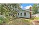 Back exterior view of charming home with brick chimney and a shade tree at 516 Windsor St, Lakeland, FL 33803