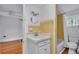 Vintage bathroom with retro yellow tiles and white fixtures, including a sink and shower-tub combo at 516 Windsor St, Lakeland, FL 33803