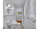 Bathroom featuring a pedestal sink, toilet, and built-in shelves with natural light at 516 Windsor St, Lakeland, FL 33803