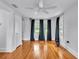 Sun-filled bedroom boasts hardwood floors, a ceiling fan, neutral walls and a window with curtains at 516 Windsor St, Lakeland, FL 33803