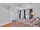 Bedroom featuring a ceiling fan, windows with curtains, and a neatly made pink bed at 516 Windsor St, Lakeland, FL 33803