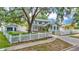 Beautiful light blue two-story home with a white picket fence, lush yard and a detached garage at 516 Windsor St, Lakeland, FL 33803